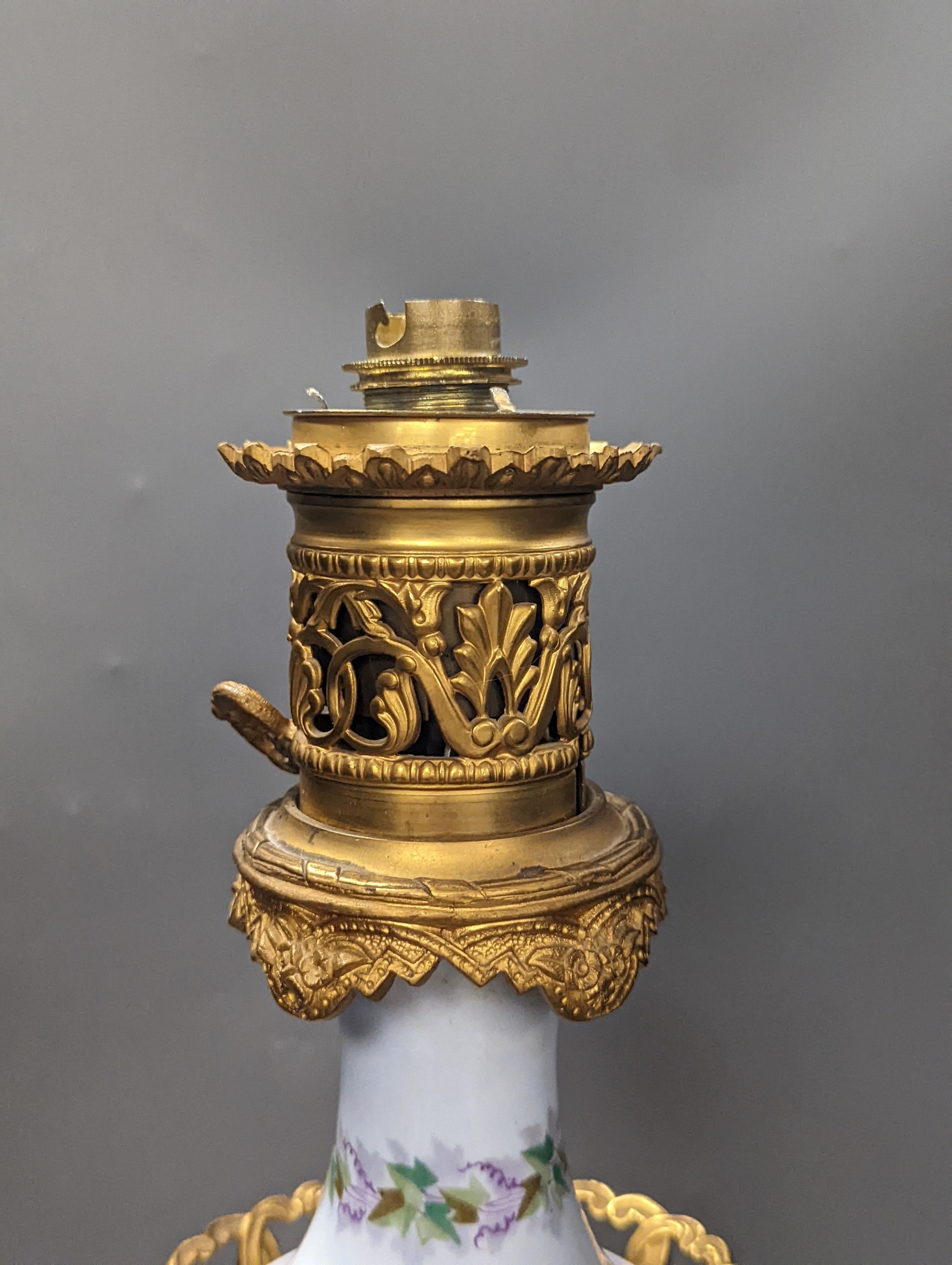 A French 19th century porcelain and ormolu oil lamp (later converted to an eclectic lamp), 54 cms high.